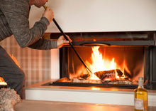 Ladda upp bild till gallerivisning, Picture of man standing and blowing in Firedragon to revive a fire.